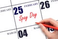 February 25. Hand writing text Spay Day on calendar date. Save the date.