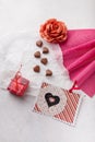 14 February Heart shaped chocolates, fabric rose, red candle on white paper, postcard. Valentines day sweets and presents Royalty Free Stock Photo