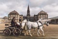 February 20, 2019. Military officer training two white horses from royal stables in front. Horses and cart with rider at