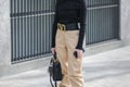 Model wears a black handbag, a black long-sleeved shirt and a pair of beige pants during the Armani fashion show at the women`s fa