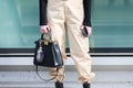 Model wears a black handbag, a black long-sleeved shirt and a pair of beige pants during the Armani fashion show at the women`s fa