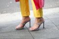 Model wears yellow pants and a pair of silver shoes open with the heel during the Armani fashion show at the women`s fashion week