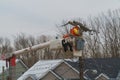 Electric service repair with bucket doing work in after the snowfall in electrician overalls working at height and dangerous