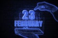 February 23rd. A hand holding a phone with a calendar date on a futuristic neon blue background. Day 23 of month.