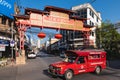 A red truck pass by the Chinese welcome gate of Chinatown, the oldest trading quarter of Chiang Mai in Thailand