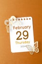 February 29th mini calendar for February 2024 and butterfly paper on orange background