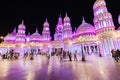 Visitors and tourists walk through the streets of the Global Village illuminated in the evening with