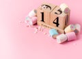 February 14 wooden calendar with pink, blue, yellow and white marshmallows and hearts on a pink background. Valentines day. Copy Royalty Free Stock Photo