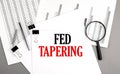 FED TAPERING text on paper on chart background