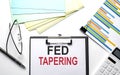 FED TAPERING text on paper sheet with chart,color paper and calculator