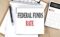 FEDERAL FUNDS RATE is written in white notepad near a calculator, clipboard and pen. Business concept Royalty Free Stock Photo
