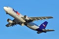 FedEx cargo aircraft takes off in blue bacckground Royalty Free Stock Photo