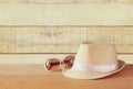 Fedora hat and sunglasses over wooden table. relaxation or vacation concept