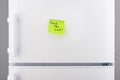 Feed the cat note on green sticky paper on refrigerator Royalty Free Stock Photo