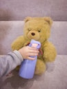 feed the teddy bear from a thermos,a little girl is playing with a teddy bear, let the teddy bear drink from her hand Royalty Free Stock Photo