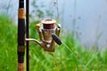 Feeder fishing rod with coil on the stand against the background of the river and grass. Feeder fishing in English style. The Royalty Free Stock Photo