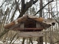 Feeder for winter feeding of birds. Birdhouse on a tree for squirrels and animals. Homemade bird house in the forest Royalty Free Stock Photo