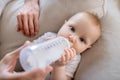 Fathers hands holding the bottle with milk for the baby Royalty Free Stock Photo