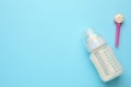 Feeding bottle with infant formula and powder on light blue background, flat lay. Space for text Royalty Free Stock Photo