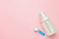 Feeding bottle with infant formula and powder on pink background, flat lay. Space for text Royalty Free Stock Photo