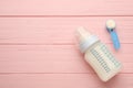 Feeding bottle with infant formula and powder on pink wooden table, flat lay. Space for text Royalty Free Stock Photo