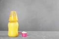 Feeding bottle with infant formula and scoop of powder on grey table, space for text. Baby milk Royalty Free Stock Photo