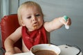 Feeding chair, eating and baby with spoon in a house for food, nutrition and fun while playing. Food, messy eater and