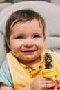 Feeding the child: a cute grimy kid with a dirty face who eats nibbler prunes sitting Royalty Free Stock Photo