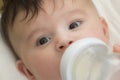 Feeding her baby. Smiling and holding a baby bottle full of milk Royalty Free Stock Photo