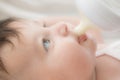 Feeding her baby. Smiling and holding a baby bottle full of milk Royalty Free Stock Photo