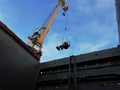 Feeding the tractor into the hold. Port work. Docker& x27;s working day. Portal crane in action. Hard and dangerous work