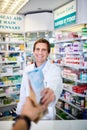 Feel better soon. Personal perspective shot of a pharmacist handing over medication to a customer in a chemist.