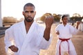 Feel the chi building...Two sportspeople practicing their kata while wearing gi.