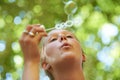 Feel like a kid again. a young woman blowing bubbles outside. Royalty Free Stock Photo