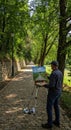 Artist Painting Tranquil Parkscape on Bright Day Royalty Free Stock Photo