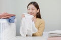 Feel softness, smiling asian young woman, girl touching fluffy towel cotton, smelling fresh clean clothes on table after washing, Royalty Free Stock Photo