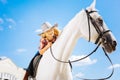 Blonde-haired cute girl feeling amazing white riding horse Royalty Free Stock Photo