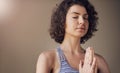 Feeling balanced and at peace. an attractive young woman sitting alone and meditating indoors.