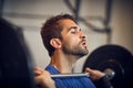 Feeling the burn. a handsome young man lifting weights while working out in the gym. Royalty Free Stock Photo