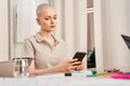 Busy woman sitting with smartphone while preparing to the rally about women& x27;s rights