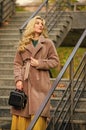 Feeling cold. sexy blong woman. autumn season. european winter. girl warm coat stairs background. faux fur coat fashion