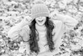 Feeling comfortable. childhood happiness. beauty of fall nature. happy kid wear sweater and hat. teen girl among fallen Royalty Free Stock Photo