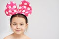 Feeling dotty. Studio portrait of a cute little girl wearing an alice band with a big bow on it. Royalty Free Stock Photo