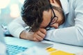 Feeling down in the dumps after a stressful work day. a young businessman with his head down on an office desk.