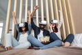 Handsome laughing afro american man with his caucasian wife and mixed race daughter, using virtual reality devices and Royalty Free Stock Photo