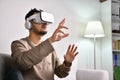 Feeling excited and amazed. Young Asian man wearing VR goggles while playing video games with hands reaching out to touch somethin Royalty Free Stock Photo