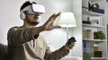 Feeling excited and amazed. Young Asian man wearing VR goggles while playing video games with hands reaching out to touch somethin Royalty Free Stock Photo