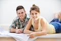 Feeling excited about their new home. Portrait of a young couple sitting with the building plans for their new home. Royalty Free Stock Photo