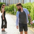 Feeling flirtatious. Bearded man and cute woman walk on street. Hipster look back at pretty woman. Couple in love on