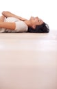 Feeling frisky on the floor. Low-angle view of a beautiful young woman lying on her back on a wooden floor.